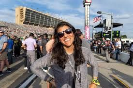 Arlette Fernandez stands in a professional setting while discussing her role in NASCAR international operations.