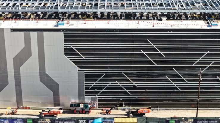 An aerial view of a large multi-level data center under construction in California, representing AI infrastructure growth.