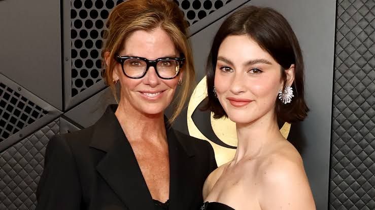 Gracie Abrams and producer Katie McGrath posing on a red carpet at a media event.