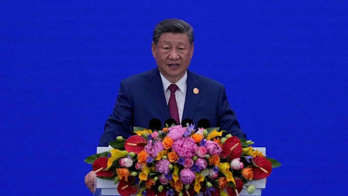 Xi Jinping speaking at a public podium regarding national industrial policy and technological advancement.