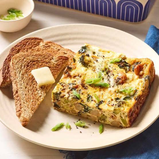 A colorful sheet-pan breakfast featuring roasted eggs, Swiss chard, mushrooms, and red peppers.