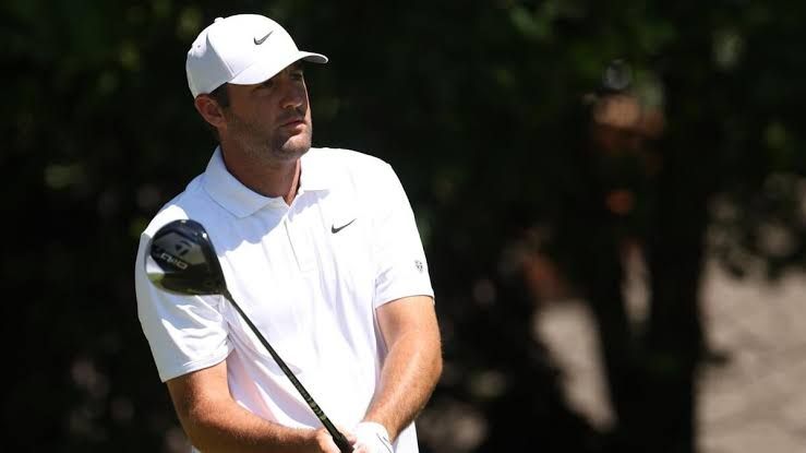 Scottie Scheffler swinging a golf club on the course during a tournament.