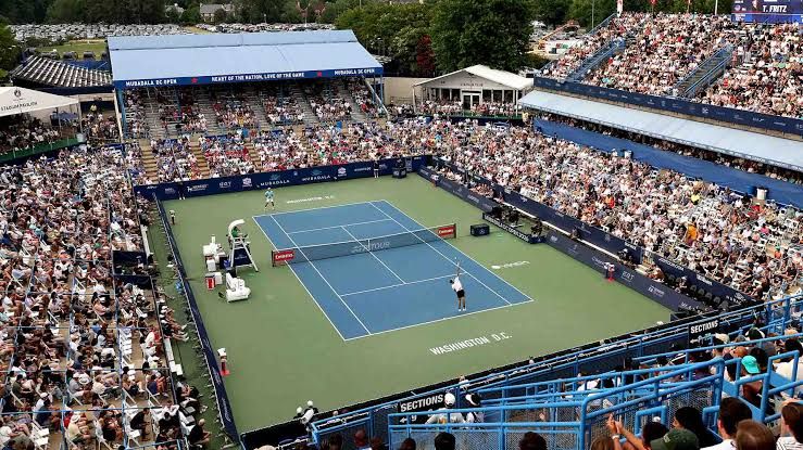 The Mubadala DC Open hard-court tennis stadium in Washington, D.C. under cloudy, wet weather conditions.
