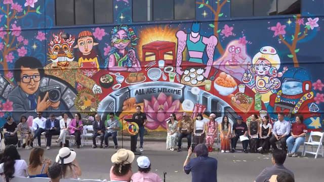 GONZO247 and six Taiwanese artists stand before their new colorful mural of a banquet table on Bellaire Boulevard.
