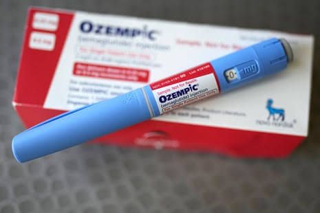 Blue Ozempic injection pen resting on its packaging box.