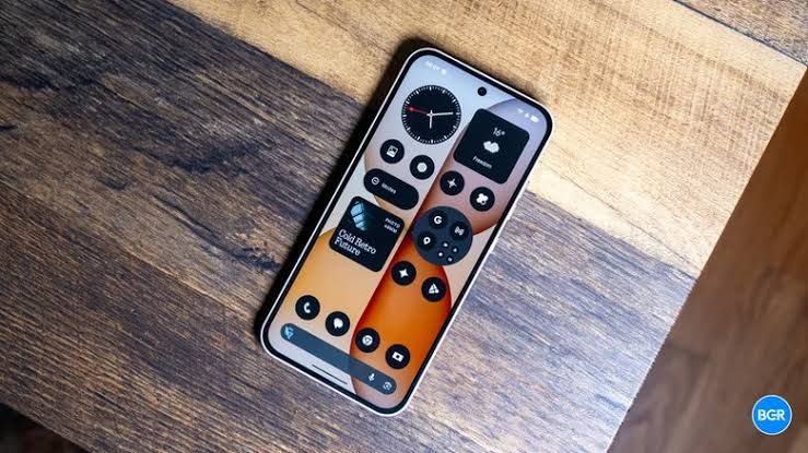A powered on Nothing Phone 4(b) smartphone showing the company interface on the display.