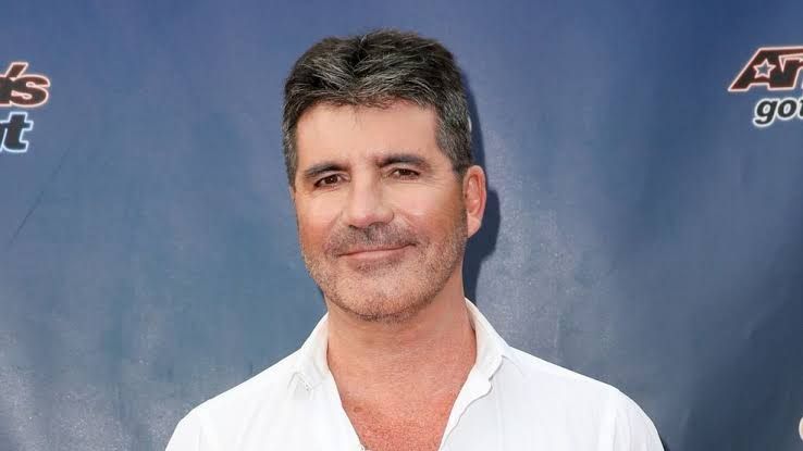 Simon Cowell smiling on the red carpet at an America's Got Talent event in Pasadena.