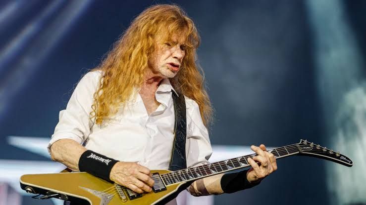 Dave Mustaine performing live on stage with his guitar during a 2026 concert appearance.