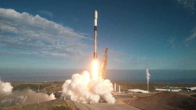 Falcon 9 rocket lifting off from Space Launch Complex 4E at Vandenberg Space Force Base against a clear sky.