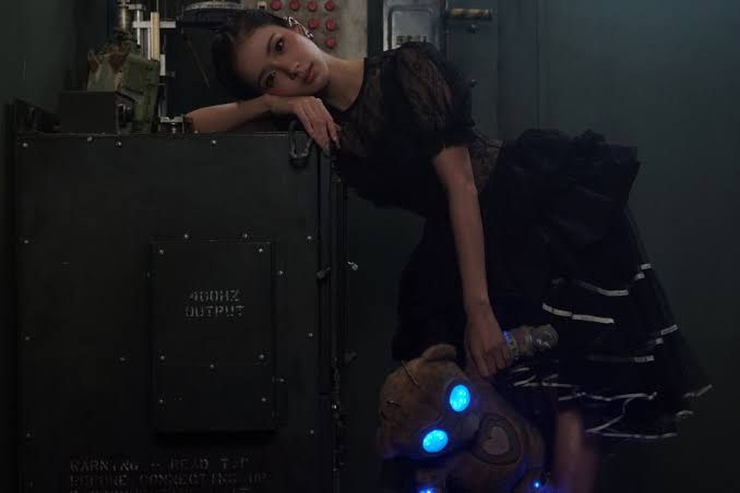 JISOO stands in a desolate, futuristic theme park setting for the music video of her new solo single CLICK.