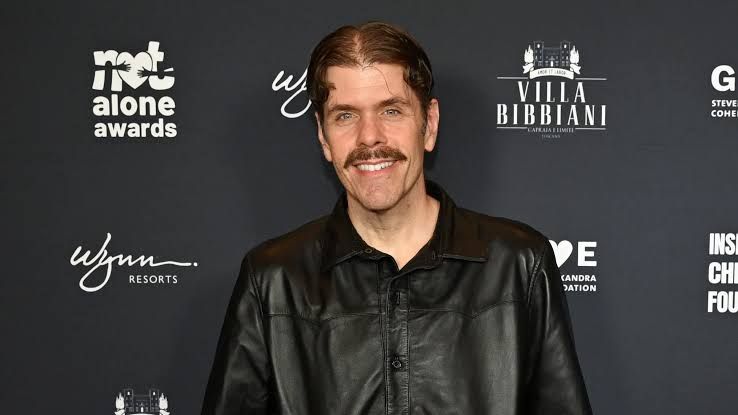 Perez Hilton appearing on a screen during a public event or broadcast.