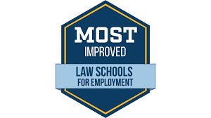 The official UMass Law Most Improved Law Schools for Employment badge displayed on a digital screen.