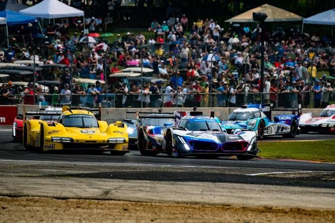 Race cars navigate a corner at the Road America track during the IMSA WeatherTech SportsCar Championship event.