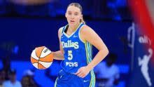 Paige Bueckers dribbling a basketball during a WNBA game between the Dallas Wings and Chicago Sky.