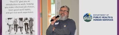 Gary Hicks speaking into a microphone at a Vocational Rehabilitation and Blind Services event.