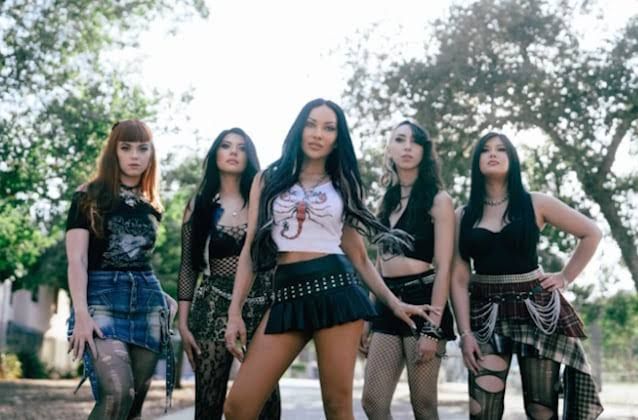 Carla Harvey stands on stage with her band, The Violent Hour, during a high-energy performance.