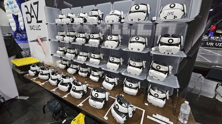 Jeff Basladynski sits in a convention booth surrounded by VR headsets and his custom wooden chopsticks.
