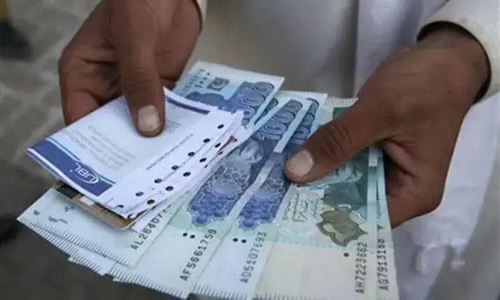 Close-up of hands counting Pakistani banknotes as part of the national pension reform announcement.