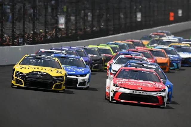 Ty Gibbs and Carson Hocevar lead a NASCAR Cup Series race restart at the Indianapolis Motor Speedway.