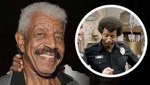 Actor Hal Williams attends an event for The Waltons, wearing a suit and smiling for the camera.