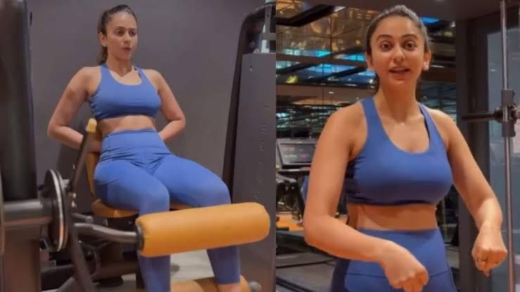 Rakul Preet Singh performing a squat with a barbell while wearing a protective waist belt in a gym.
