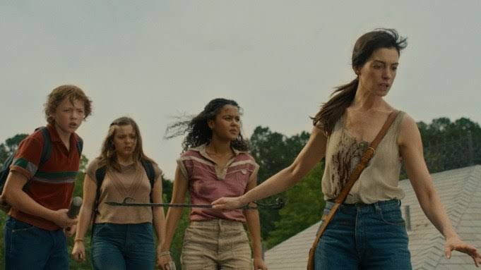 Anne Hathaway acts in The End of Oak Street, a film about a neighborhood facing a sudden prehistoric jungle invasion.