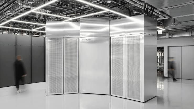 A technician working with the modular hardware of an IBM Quantum System Two in a high-tech laboratory environment.