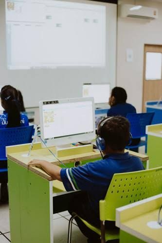 Students using computers in a classroom setting, illustrating the reliance on technology in modern education.