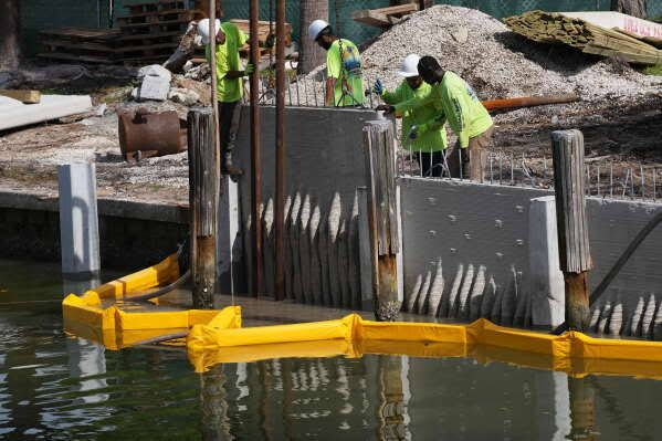 A 3D-printed living seawall mimicking mangrove roots installed by workers at a waterfront church in Fort Lauderdale.