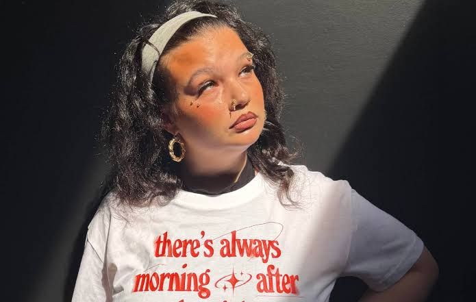 Singer Lola Young wearing a branded CALM Lifelines T-shirt during a mental health awareness campaign.