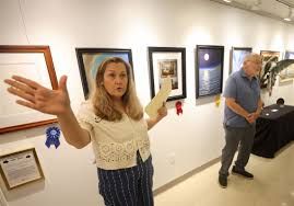 Linda Shetzer talks to guests during an exhibit at the Toledo Artists' Club at the Toledo Botanical Garden.
