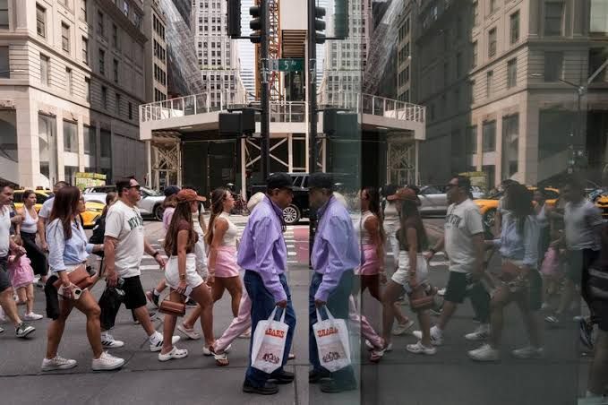 A New York Federal Reserve building sign outside with people walking past during a busy workday.