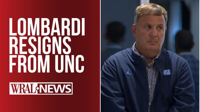 Michael Lombardi standing on the sidelines at a UNC football practice while wearing team apparel.