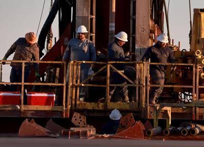 Workers on an oil drilling rig in the Permian Basin, Texas, highlighting the state's economic energy sector.