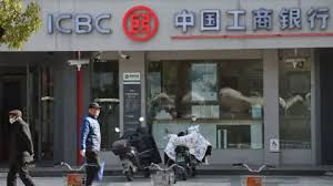 People seeking shade near a closed ICBC service center in Chongqing as part of China's economic shifts.