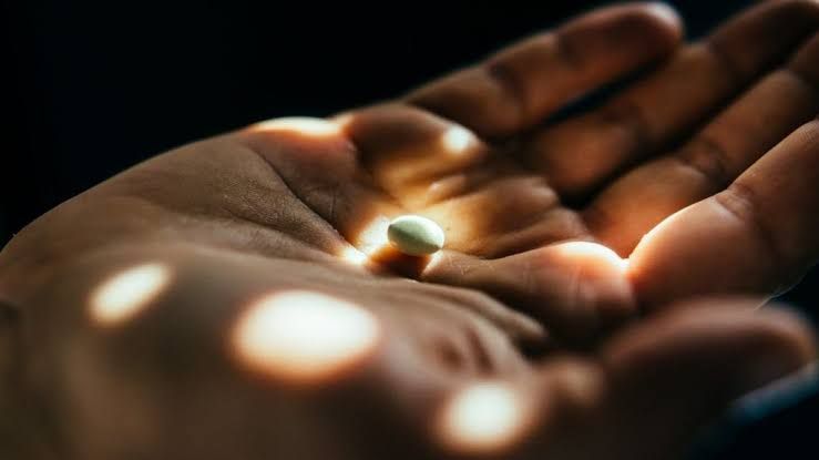 Close-up of a single Lipfendra pill held in an open palm to illustrate the new oral cholesterol treatment.