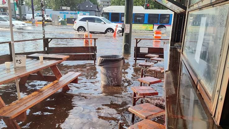 Flooded basement floor of The Squire Lounge in Denver filled with debris and mud after heavy rain.