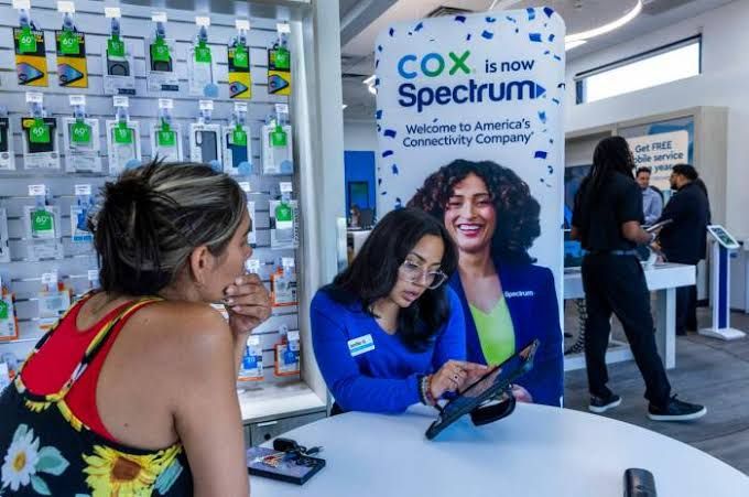 Sales associate assists a customer in a retail store as Cox Communications transitions to the Spectrum brand in Las Vegas.