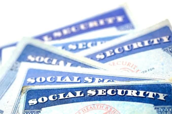 Social Security cards lying on a clean white surface to represent federal benefits.
