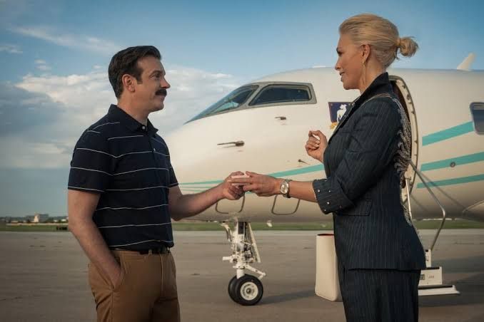 Ted Lasso standing on a football pitch during the season four premiere on Apple TV.