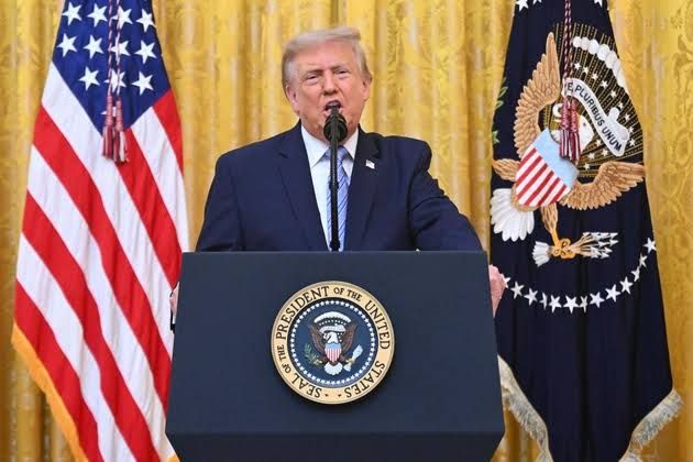President Donald Trump speaking from a podium in the White House East Room during a July 2026 press event.
