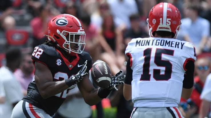 Kirby Smart speaking at a podium during SEC Media Days regarding the injury status of Dante Dowdell.