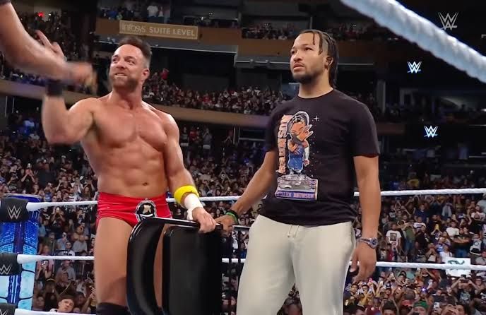 Roman Reigns and Jalen Brunson standing together at a professional wrestling event inside Madison Square Garden.