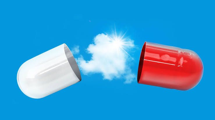 A stylized red and white pill capsule opening to reveal a bright blue sky and clouds.