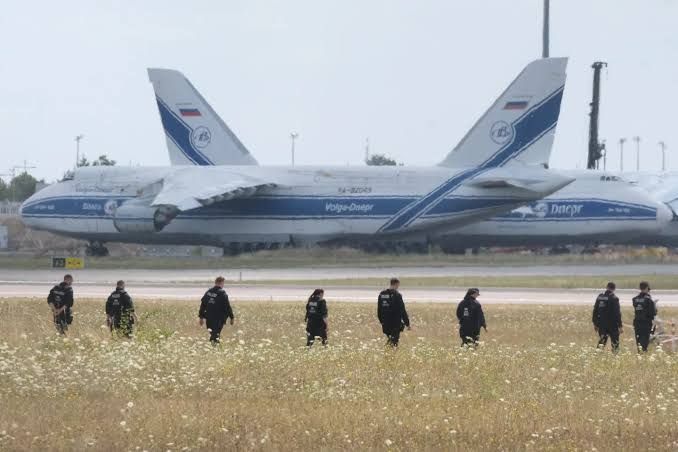 Police officers walk across the field at Leipzig/Halle Airport following the discovery of drone debris.
