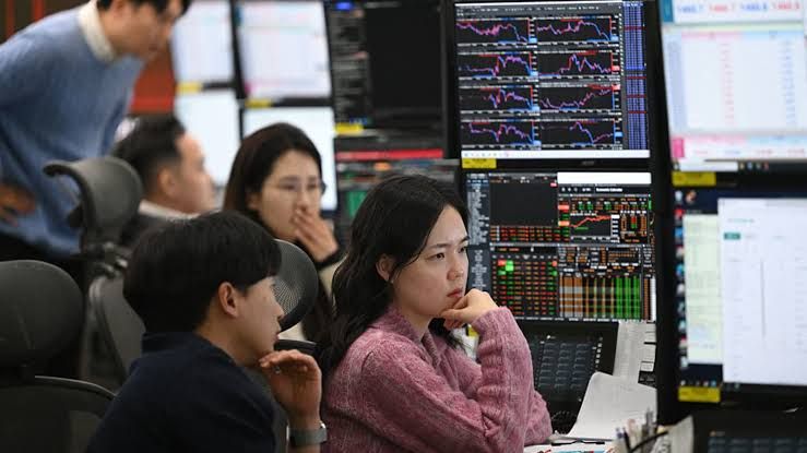 Currency dealers monitor stock market exchange rates at the Hana Bank headquarters in Seoul.