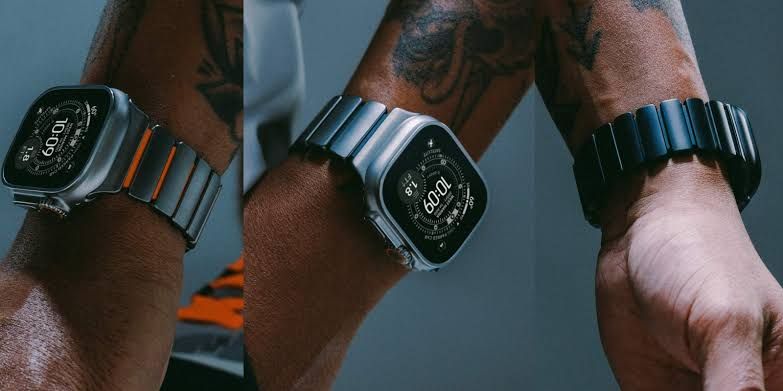 Nomad Stratos titanium watch band in black and natural finishes shown alongside the Icy Blue Glow model.
