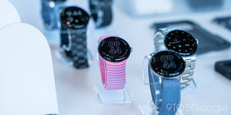 A close-up of a Google Pixel Watch with a colored sport band attached.