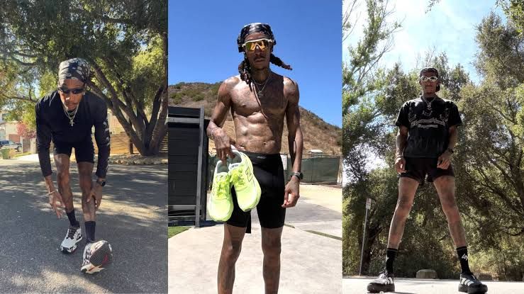 Wiz Khalifa wearing athletic gear while running outdoors and documenting his distance on a fitness tracker.