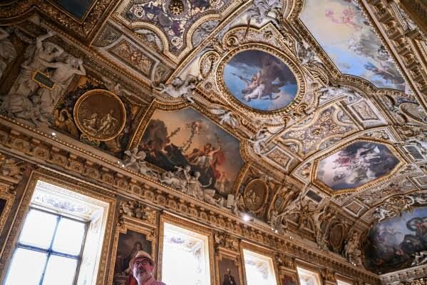 A visitor walks through the renovated Apollo Gallery at the Louvre in Paris following its reopening.
